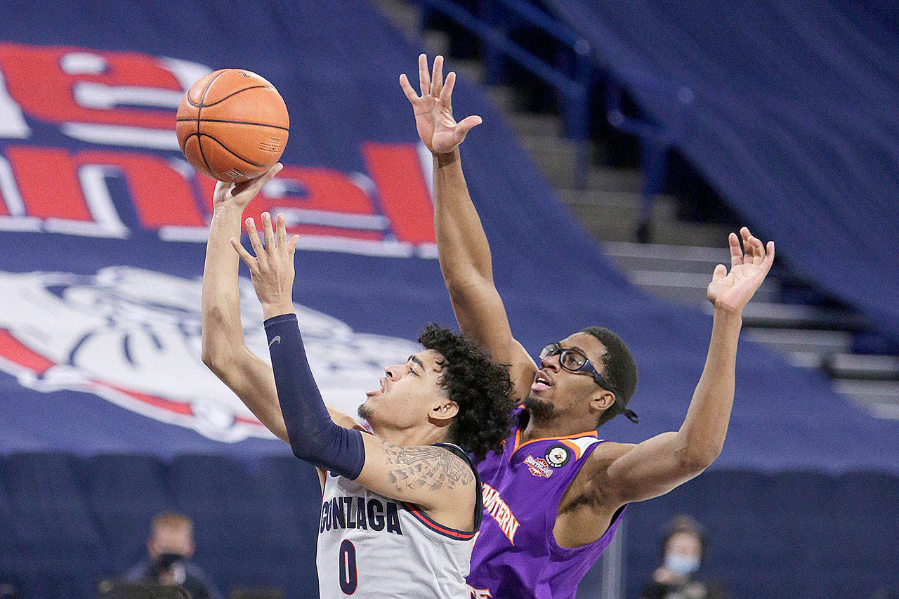 Gonzaga guard Julian Strawther, left, shoots in front of Northwestern State forward Jamaure Gregg during the second half of an NCAA college basketball game in Spokane on Tuesday. (Young Kwak / Associated Press)