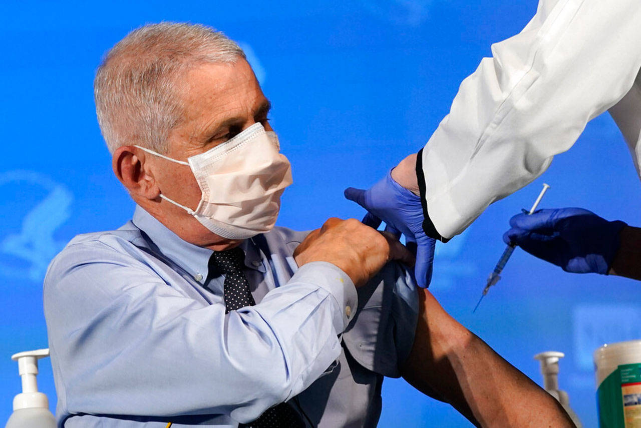 Dr. Anthony Fauci, director of the National Institute of Allergy and Infectious Diseases, prepares to receive his first dose of the covid-19 vaccine at the National Institutes of Health, Tuesday, in Bethesda, Md. (Patrick Semansky / Associated Press)