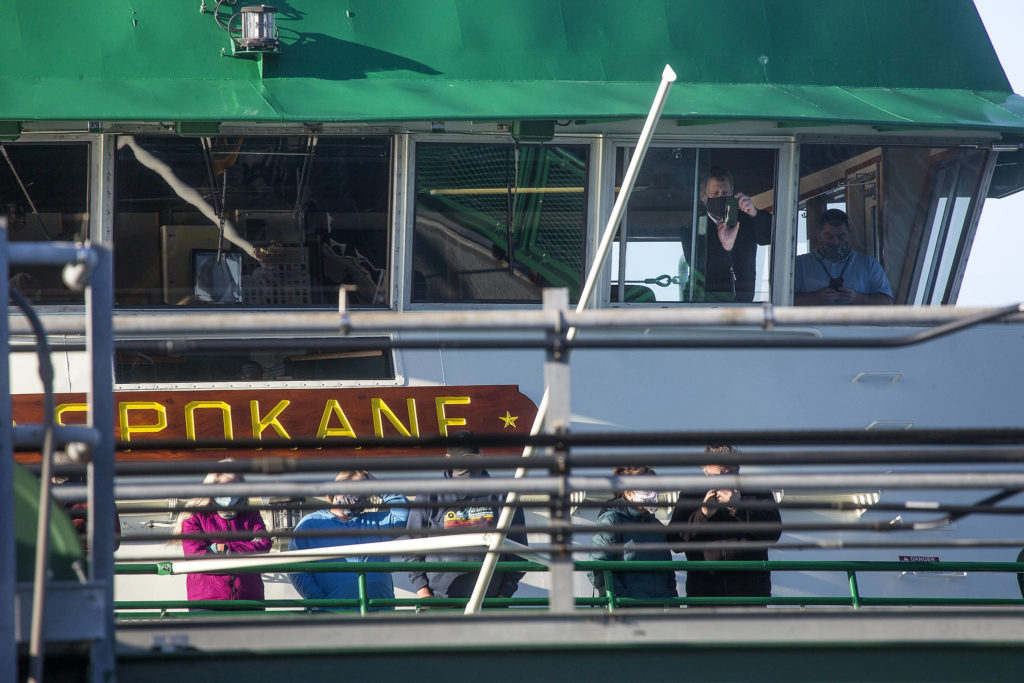 From the bridge of the MV Spokane, a Washington State Ferries crew takes photos of spilled logs blocking the ramp of the Edmonds terminal on Monday. (Andy Bronson / The Herald)
