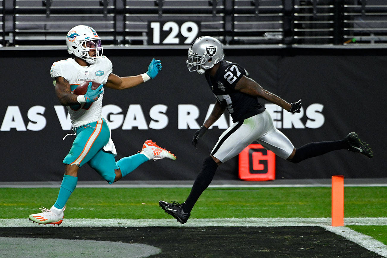 Miami Dolphins running back Myles Gaskin (37) runs for a touchdown against Las Vegas Raiders cornerback Trayvon Mullen (27) during an NFL football game, Sunday, Dec. 26, 2020, in Las Vegas. (AP Photo/David Becker)