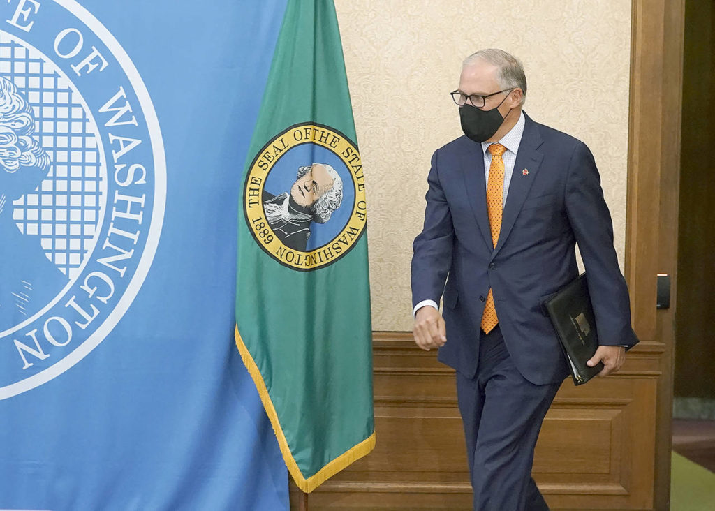 Washington Gov. Jay Inslee arrives to talk to reporters joining him remotely at the Capitol in Olympia on Nov. 4, a day after he was re-elected to a third term as governor. (AP Photo/Ted S. Warren, File)
