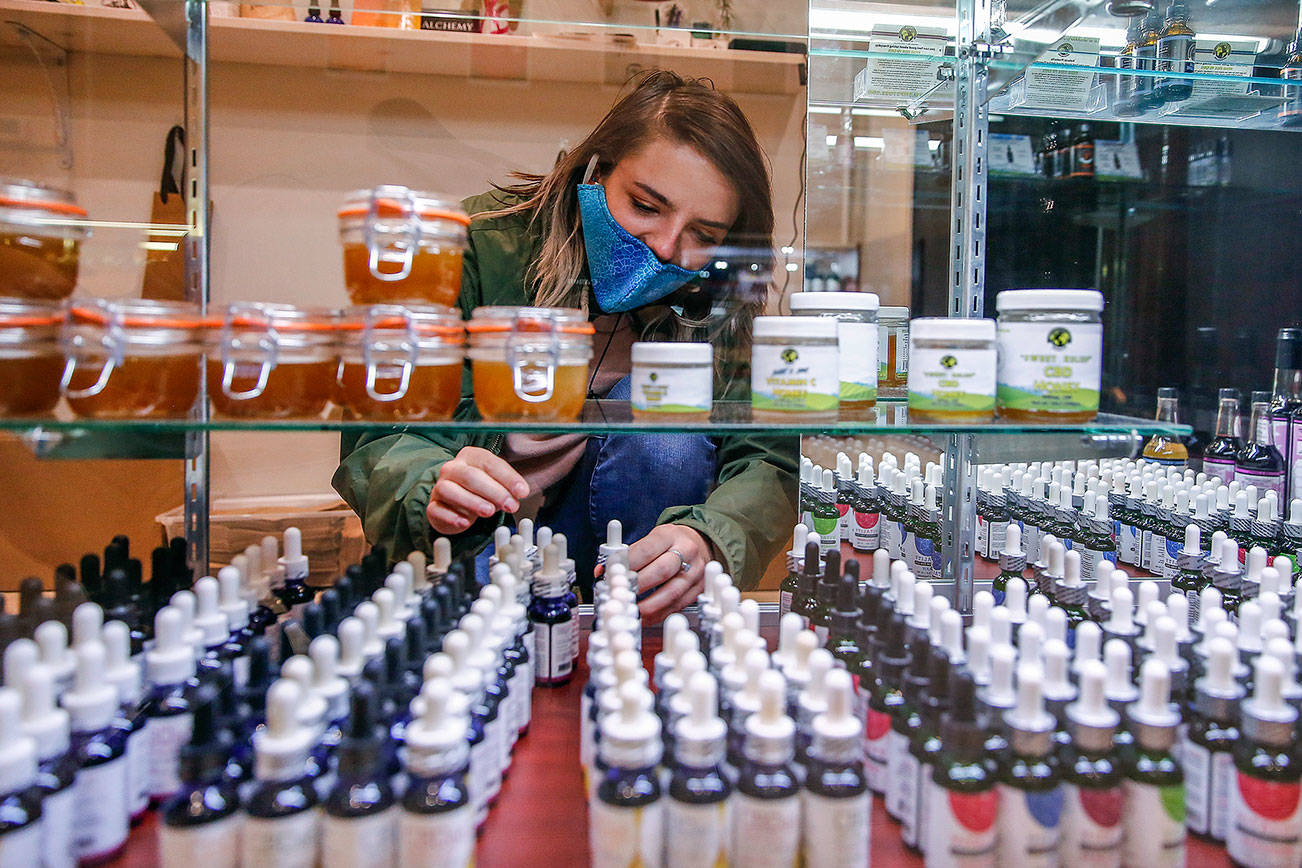 Cece Stafford arranges stock Wednesday afternoon at Alchemy Health in Alderwood Mall on December 16, 2020. (Kevin Clark / The Herald)