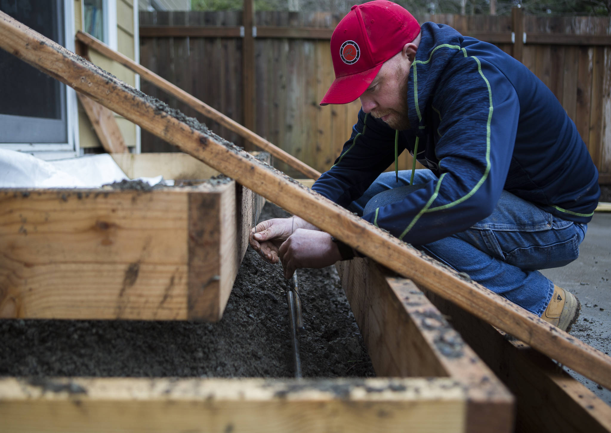 Adam Ling secures rebar reinforcement for a set of stairs at a home in Lynnwood. (Olivia Vanni / The Herald)