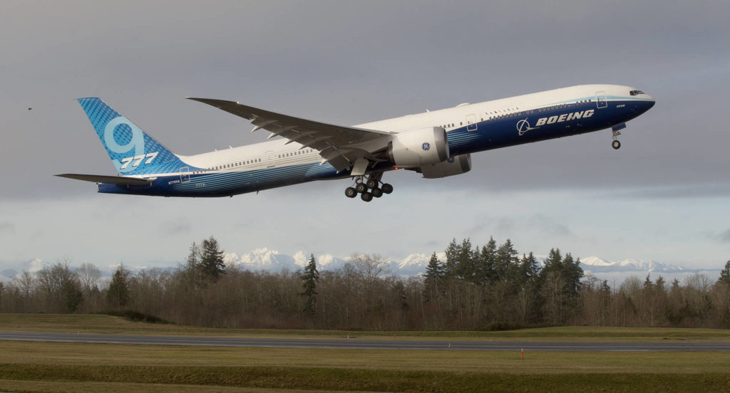 With the Olympic mountains in the background, Boeing’s 777X lifts off from Paine Field on its first flight, to Boeing Field in Seattle, on Jan. 25 in Everett. (Andy Bronson / The Herald) 
