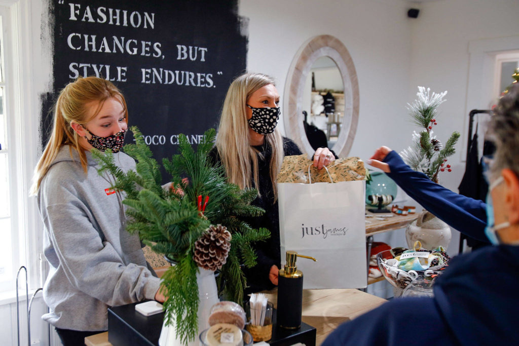 Claire Vondemkempt (left) and Jami Sollid check out customers at Just James Boutique in Stanwood on Nov. 28. (Kevin Clark / The Herald)
