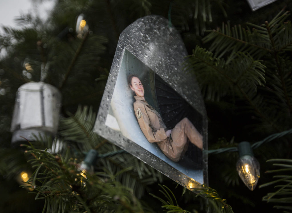 A photograph of a soldier sitting in a large airplane engine hangs on the tree on Crosby’s property in Lynnwood. (Olivia Vanni / The Herald)
