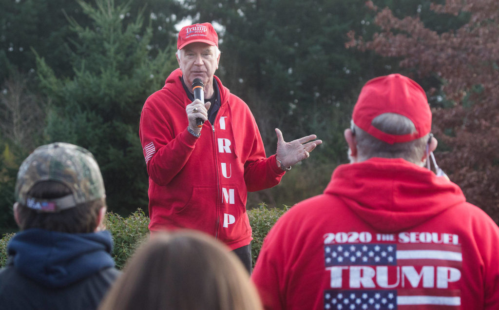 The vice chairman of the Snohomish County Republican Party, Doug Roulstone, speaks to Trump supporters at a rally at the 112th Street park-and-ride on Wednesday in Everett. (Andy Bronson / The Herald)
