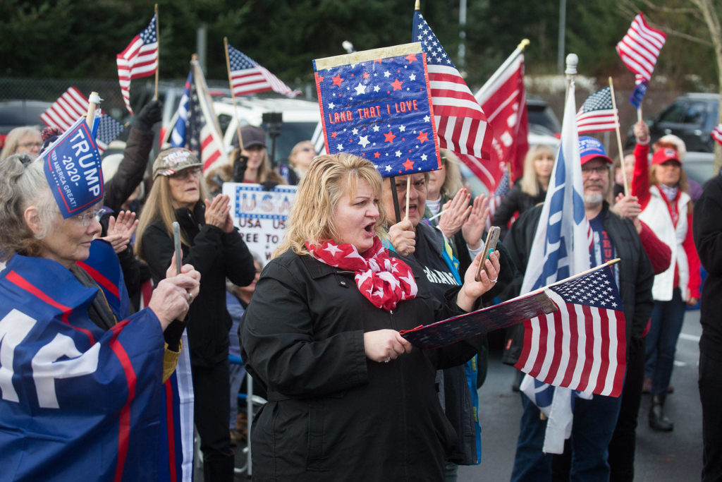 Supporters of President Trump cheer at a rally at the 112th Street park-and-ride on Wednesday in Everett. (Andy Bronson / The Herald) 
