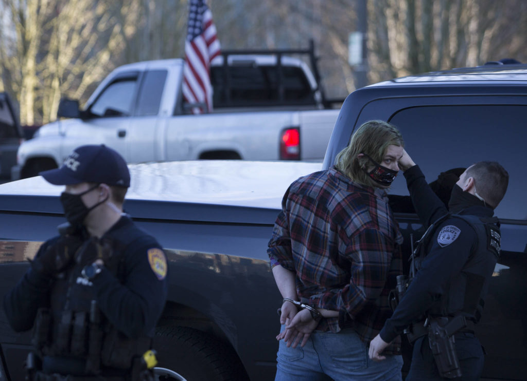 A man is briefly detained before being let go after an altercation with a Trump supporter in front of the Snohomish County Courthouse on Wednesday, Jan. 6, 2020 in Everett, Wa. (Olivia Vanni / The Herald)
