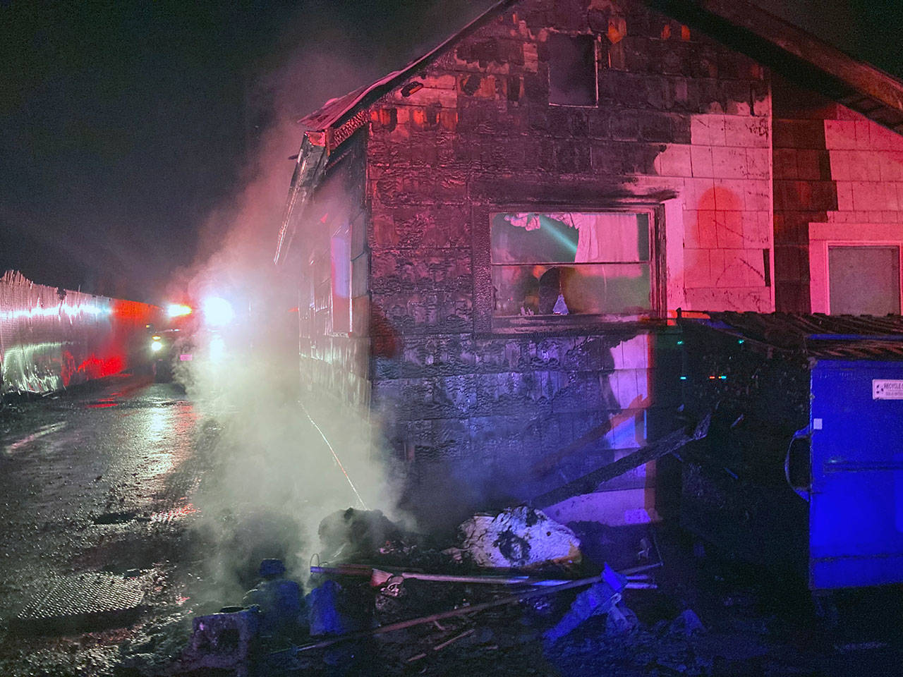First responders arrived to find two dumpsters burning adjacent to a home in Monroe on Wednesday. (Monroe Police Department)