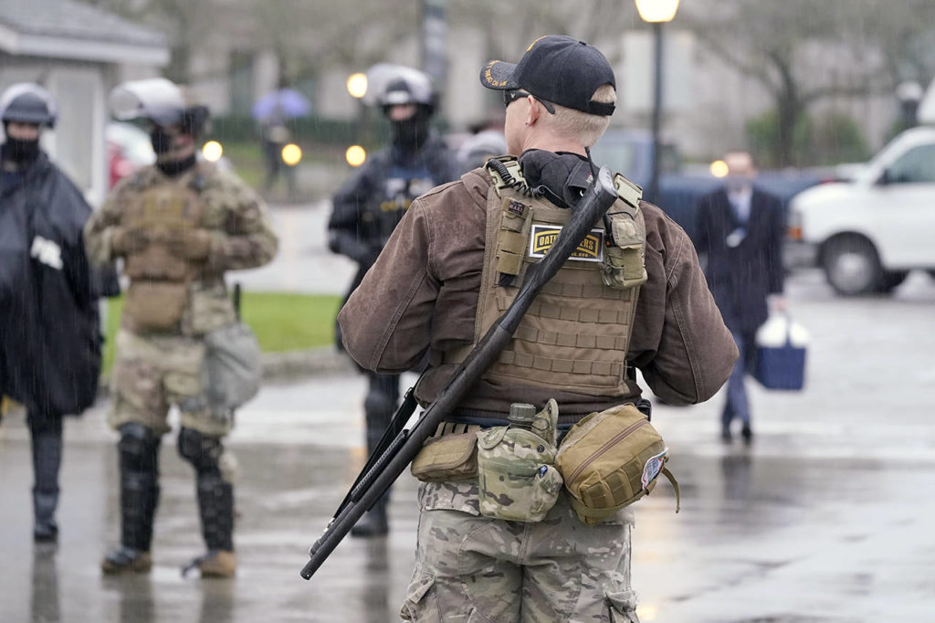 An armed protester stands outside the Capitol Monday in Olympia. According to organizers, some protesters are unhappy the Legislature will meeting virtually and in sessions not open to the public, due to the COVID-19 pandemic, during the 2021 session which opens Monday. (AP Photo/Ted S. Warren)
