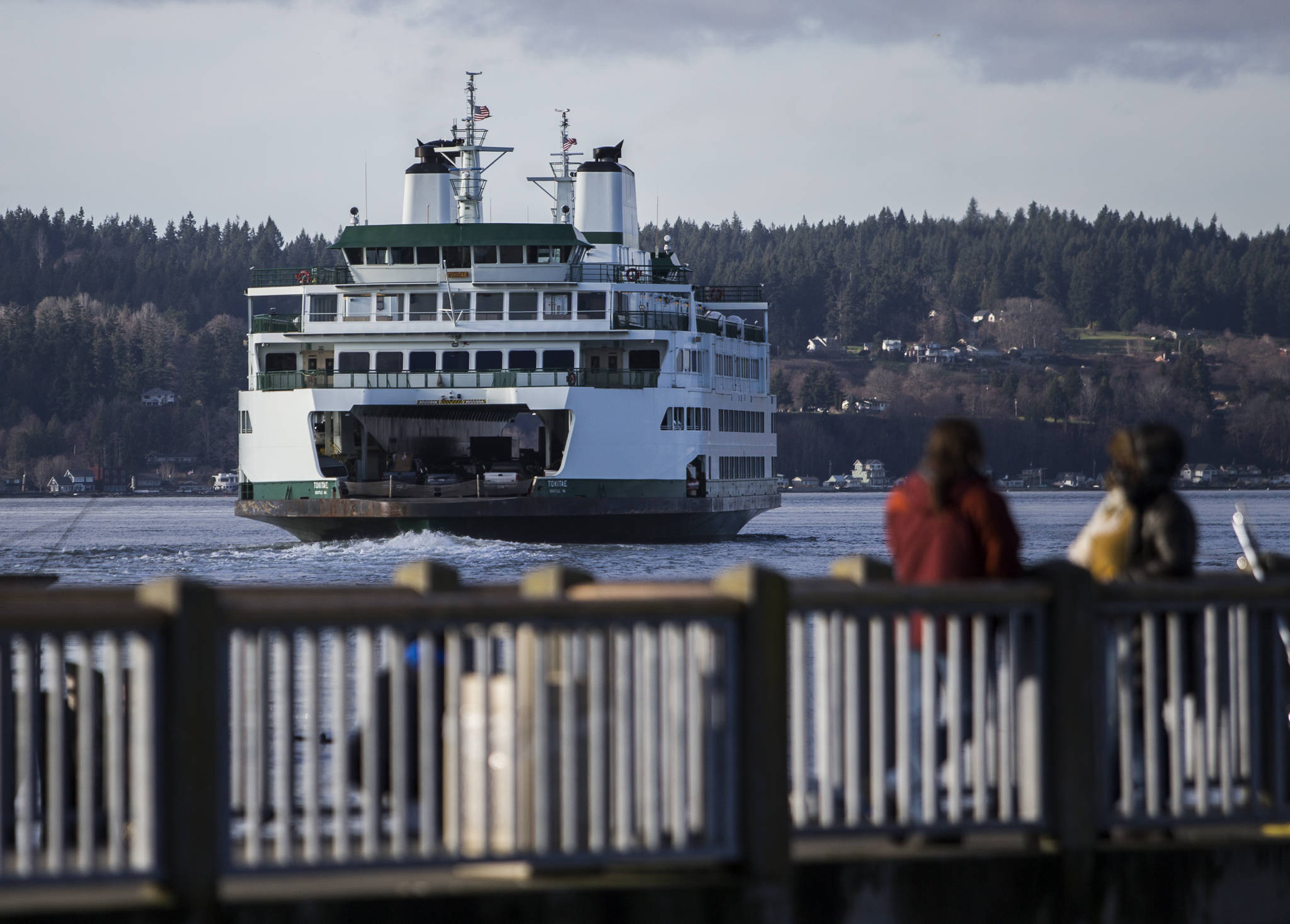 People watch as a ferry boat leave the Mukilteo ferry terminal on Tuesday, Dec. 22, 2020 in Mukilteo. (Olivia Vanni / The Herald)