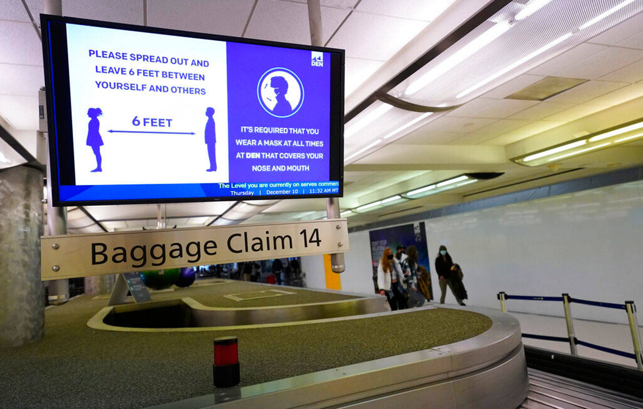 An electronic sign warns travellers to maintain social distance in the terminal of Denver International Airport in Denver in mid-December. Following reports of rowdy passengers returning from protests in Washington, D.C., the FAA now is threatening fines of up to $35,000 for passengers who are unruly and fail to comply with airline mask mandates. (David Zalubowski / Associated Press file photo)