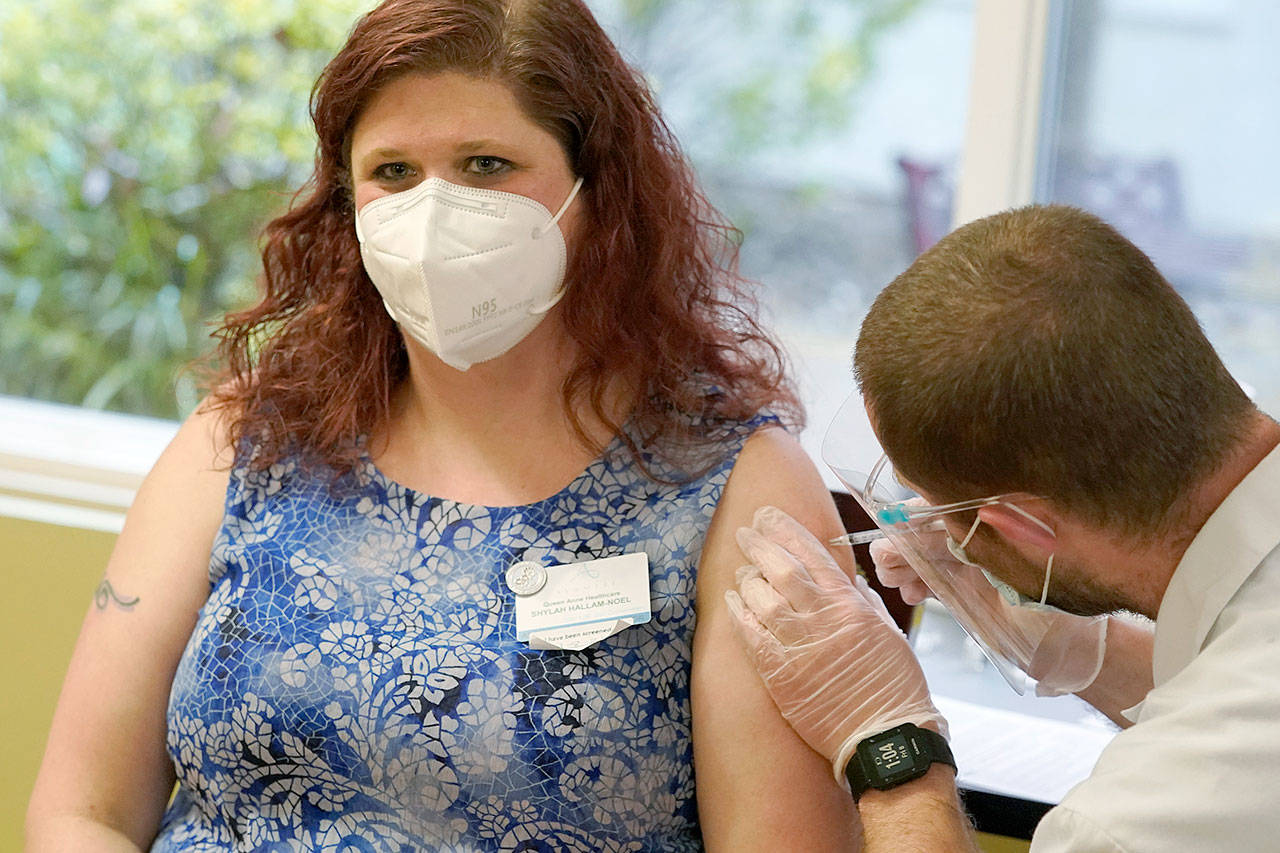 Shylah Hallam-Noel, a worker at Queen Anne Healthcare in Seattle, receives the second shot of the Pfizer vaccination for COVID-19. (Ted S. Warren / Associated Press)
