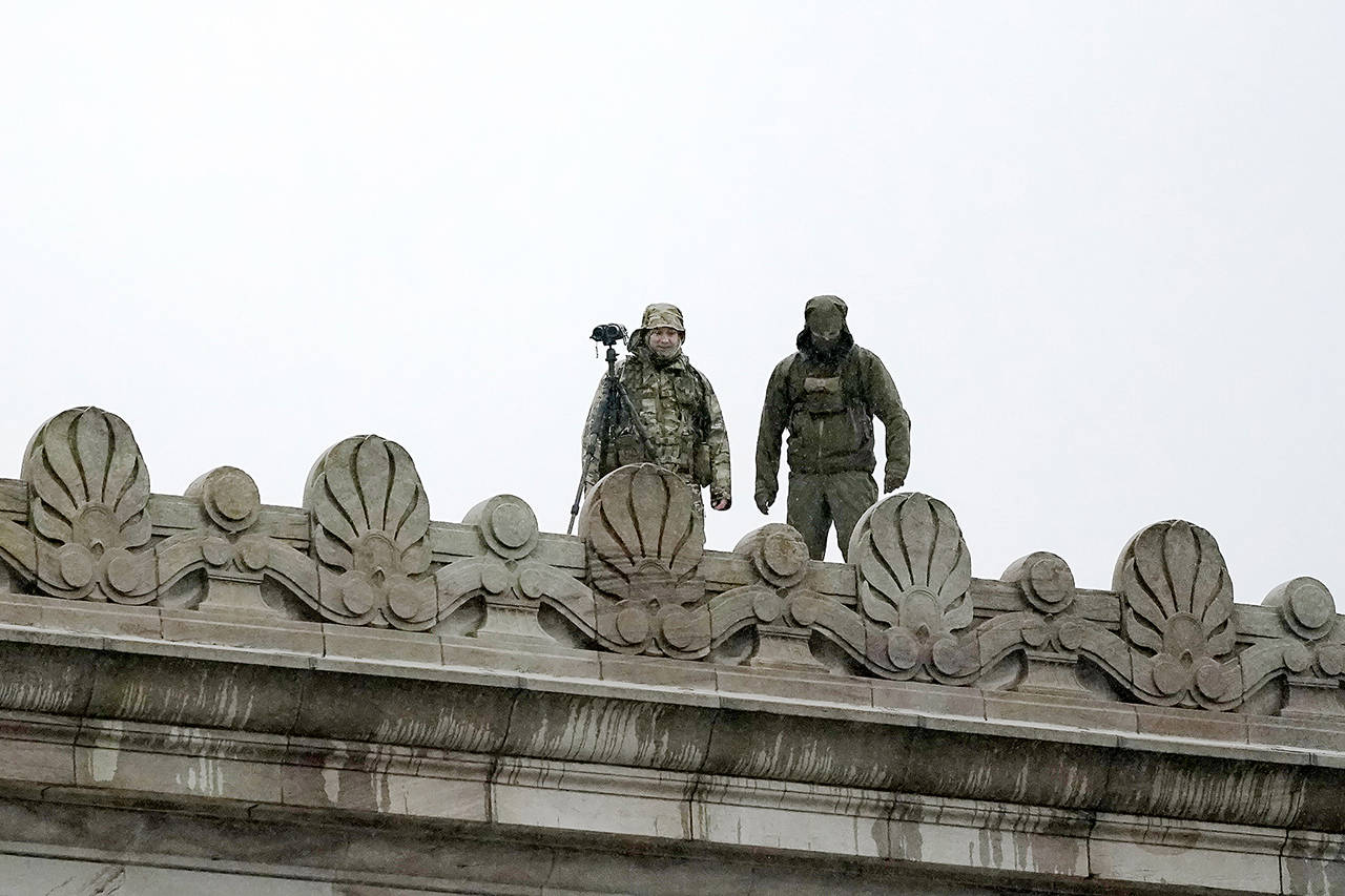 Law enforcement officers stand atop the Capitol in anticipation of protests Monday at the Capitol in Olympia. (AP Photo/Ted S. Warren)