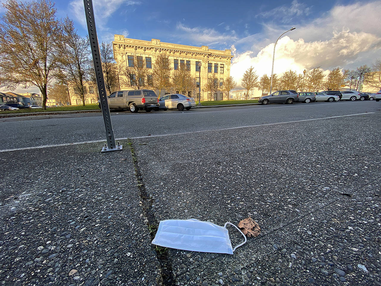 A discarded face mask lies on the sidewalk across the street from Everett High School last December. (Sue Misao / The Herald)