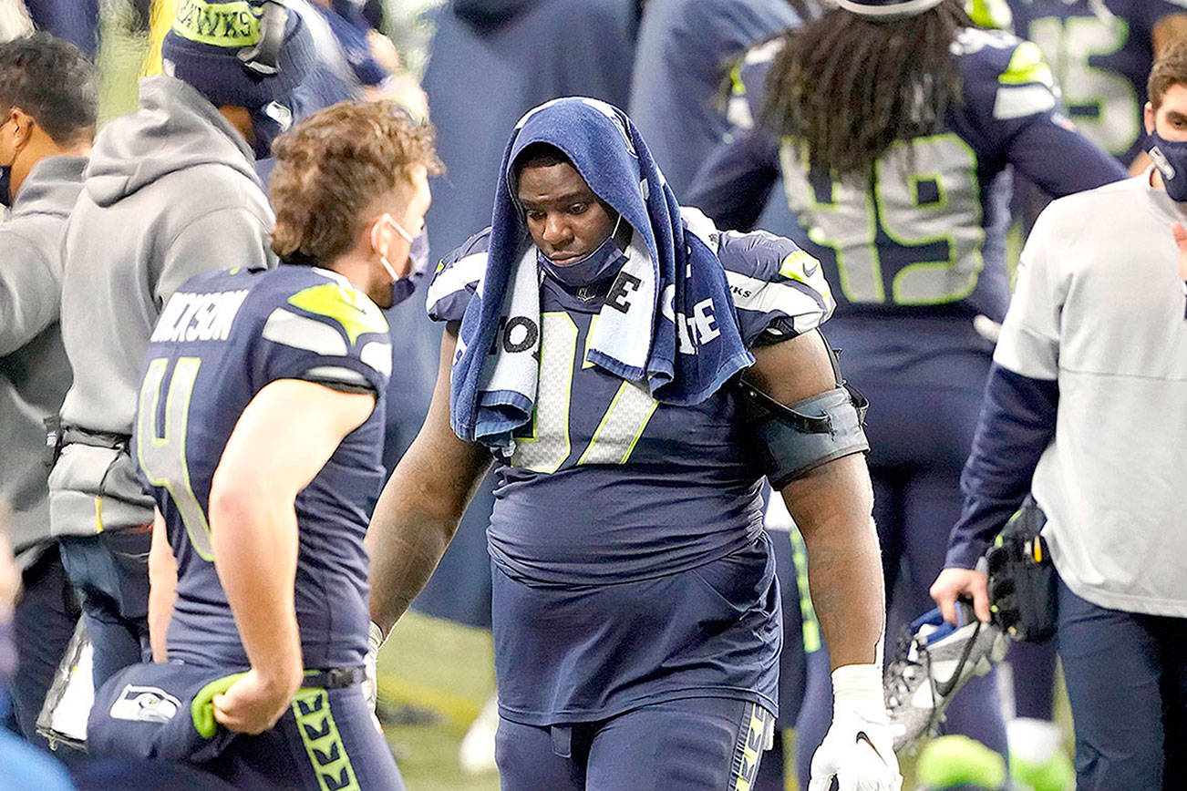 Seattle Seahawks defensive tackle Poona Ford turns away from the field as he stands at the bench late in the second half of Seattle’s playoff loss to the Los Angels Rams last Saturday at Lumen Field. (AP Photo/Ted S. Warren)