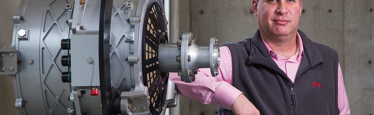 Roei Ganzarski, CEO of magniX, poses with a production electric engine, the magni500, at the  company's new office on Seaway Boulevard on Monday, Jan. 18, 2020 in Everett, Washington.  (Andy Bronson / The Herald)