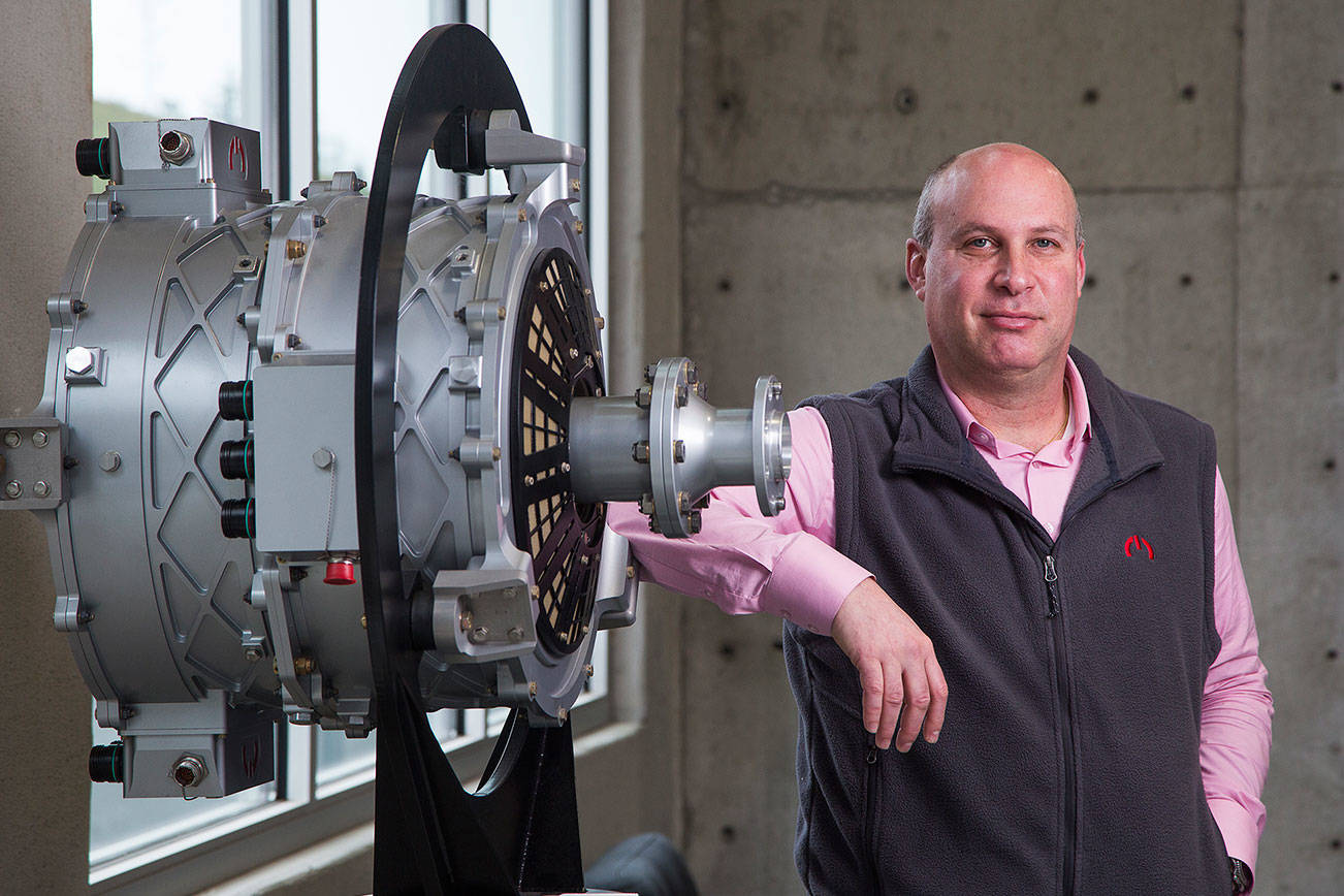 Roei Ganzarski, CEO of magniX, poses with a production electric engine, the magni500, at the  company's new office on Seaway Boulevard on Monday, Jan. 18, 2020 in Everett, Washington.  (Andy Bronson / The Herald)