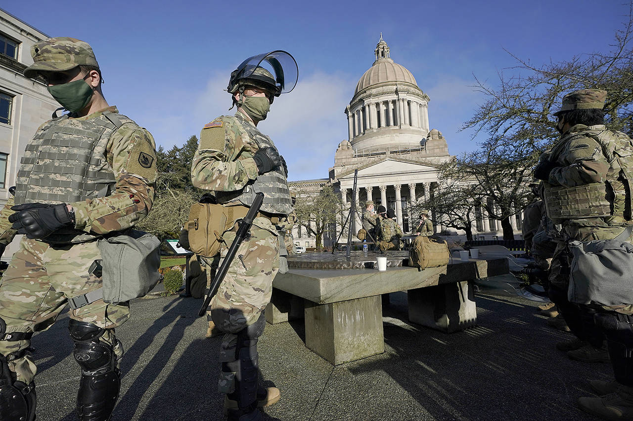 Members of the Washington National Guard stand at a sundial near the Legislative Building on Jan. 10 at the Capitol in Olympia. Nearly 400 members have been activated to support the presidential inauguration in the nation’s Capitol on Jan. 20. (AP Photo/Ted S. Warren)