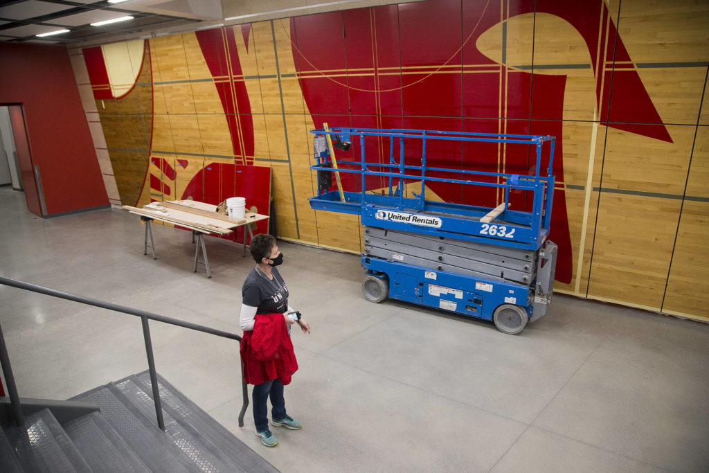 Principal Christine Del Pozo looks at a wall display made from the former school’s gym floor in the new Stanwood High School. (Andy Bronson / The Herald)
