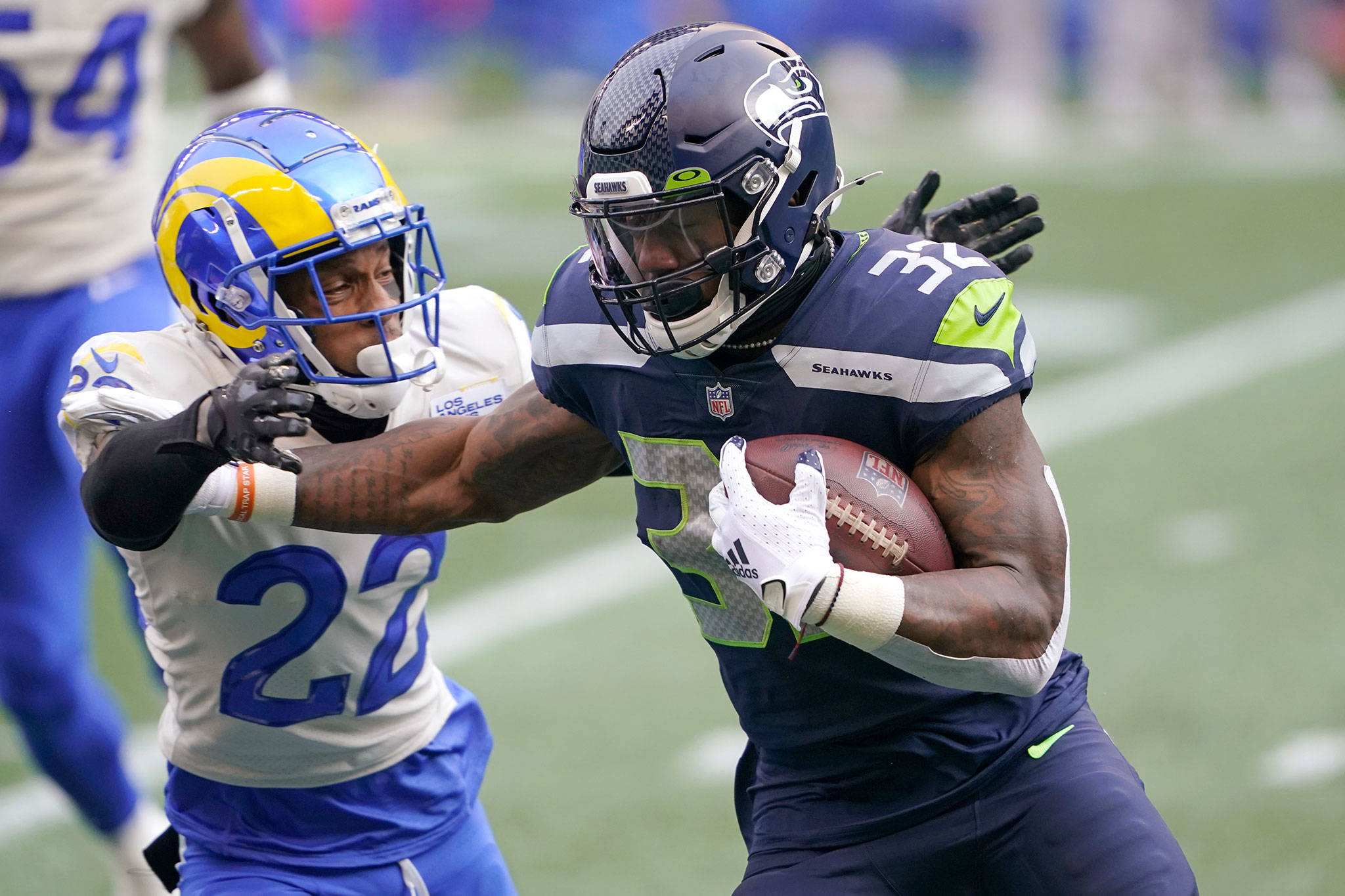 Seahawks running back Chris Carson (right) fends off Rams cornerback Troy Hill during the first half of a wild-card playoff game on Jan. 9, 2021, in Seattle. (AP Photo/Ted S. Warren)