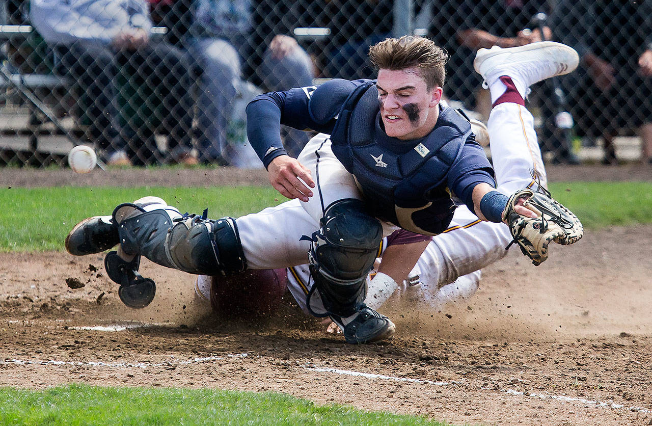 Arlington’s Jack Sheward (front) reaches for the ball as O’Dea’s David Sessoms slides into home during a 3A baseball state regional game on May 18, 2019, at Sherman Anderson Field in Mount Vernon. (Andy Bronson / The Herald)