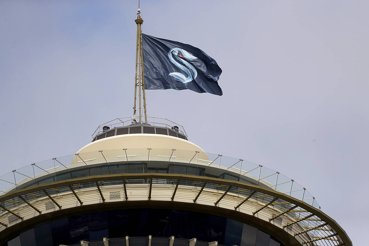 A flag with the Seattle Kraken logo flies atop the iconic Space Needle Thursday, July 23, 2020, in Seattle. (AP Photo/Elaine Thompson)