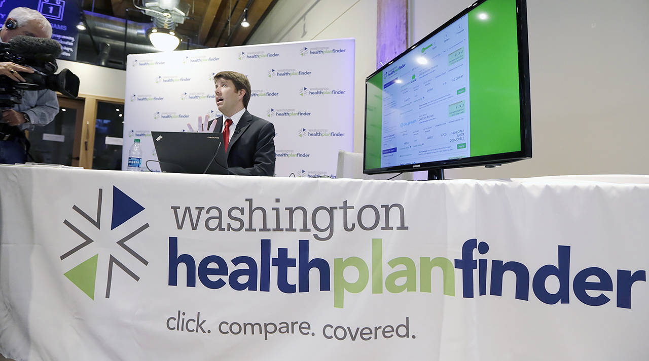 Brad Finnegan demonstrates the Washington Healthplanfinder website following a news conference in 2013 in Seattle. (AP Photo/Elaine Thompson, file)