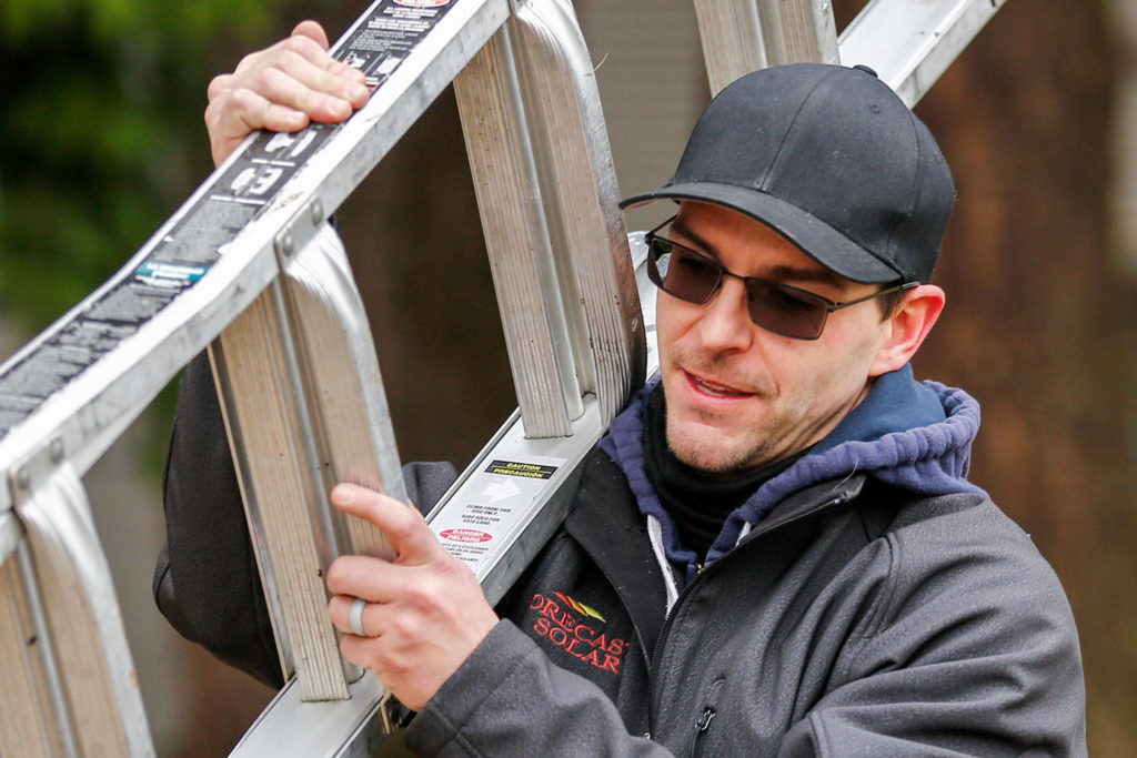 Morgan Zehrung, owner of Forecast Solar, at work at the home of Brian Aikins in Everett. (Kevin Clark / The Herald) 
