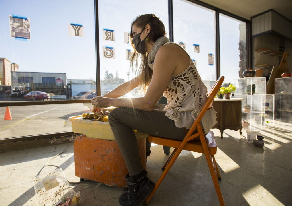 Rachel Recker works on a bowl at one of her pottery wheels in her new studio space at Salish Sea Ceramics in Everett. (Olivia Vanni / The Herald)
