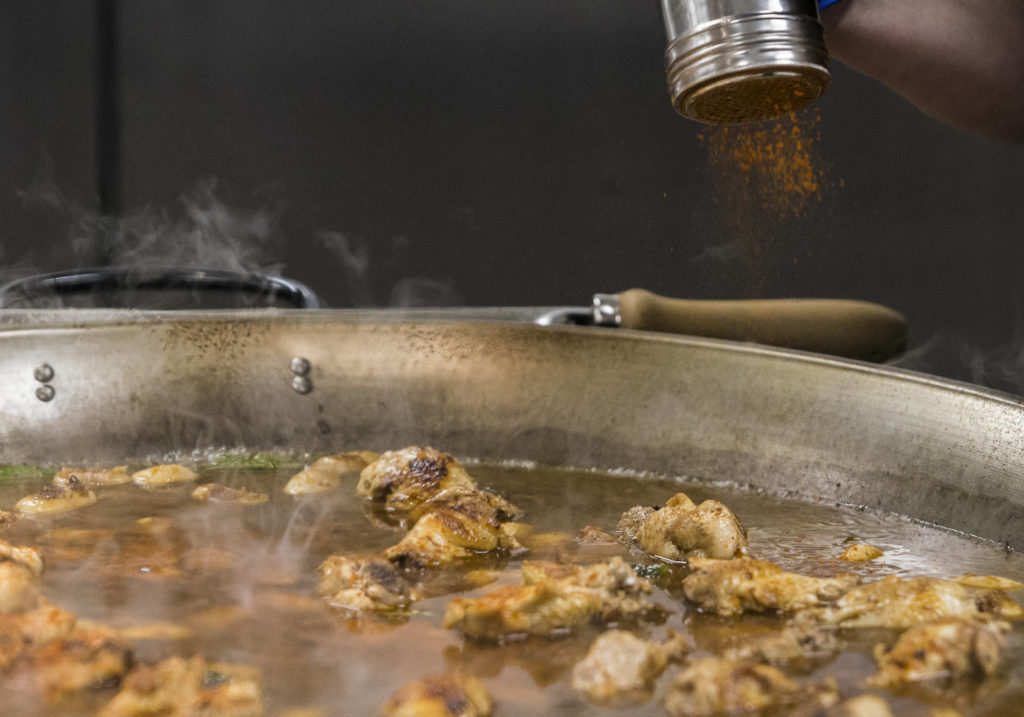 Paprika is added to a Paella Valenciana, which is based on the original paella recipe found in an 18th-century manuscript. (Olivia Vanni / The Herald)
