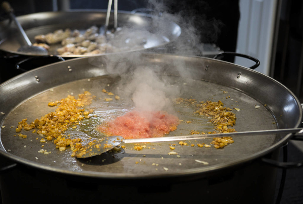 The McLaughlins start out a paella cook with onions and tomatoes. (Olivia Vanni / The Herald)
