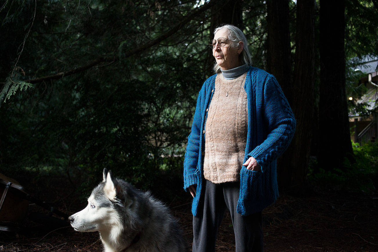 Marianne Edain, seen with her dog Takilna, is a longtime activist and, with her husband Steve Erickson, founded the Whidbey Environmental Action Network (WEAN). They are restoration ecologists by trade. Shot at home on Wednesday, Feb. 3, 2021 in Clinton, Washington. Edain, 73, has been fighting local environmental battles since 1977. “Back then, we thought (about climate change) in terms of generations,” she said. “Ten to 15 years ago, we were thinking in terms of decades. Now it’s in our face.”
 (Andy Bronson / The Herald)