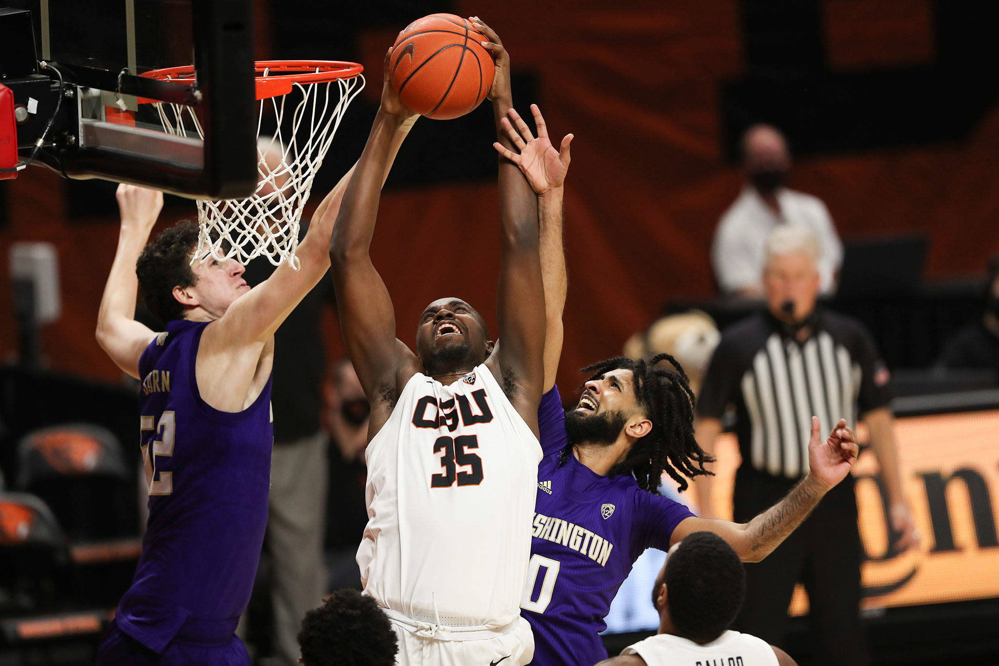 Washington’s Riley Sorn (left) and Marcus Tsohonis (right) fight with Oregon State’s Dearon Tucker for possession of a rebound during the first half of a game Feb. 4, 2021, in Corvallis, Ore. (AP Photo/Amanda Loman)