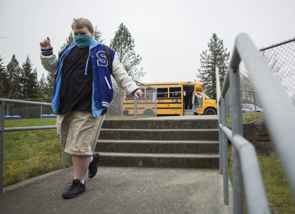 A student walks from the school bus to the high school on Thursday in Sultan. (Olivia Vanni / The Herald) 
