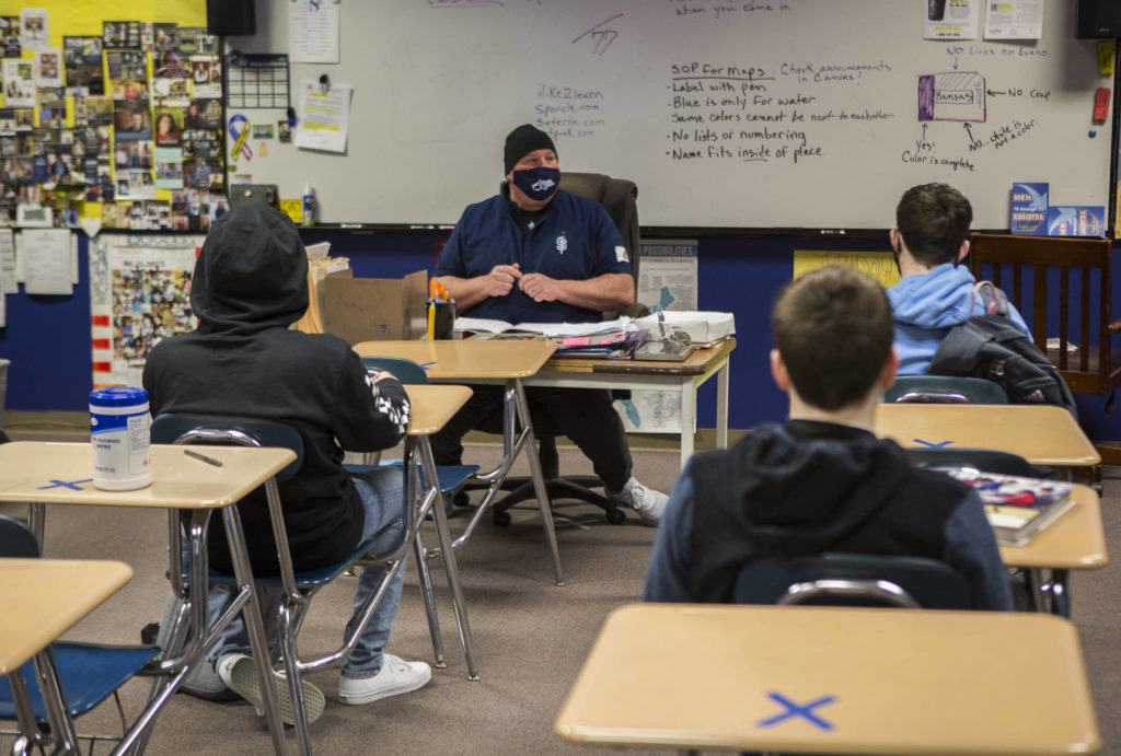 Students sit social distanced, with sanitizing wipes within reach, during a social sciences class on Thursday in Sultan. (Olivia Vanni / The Herald) 
