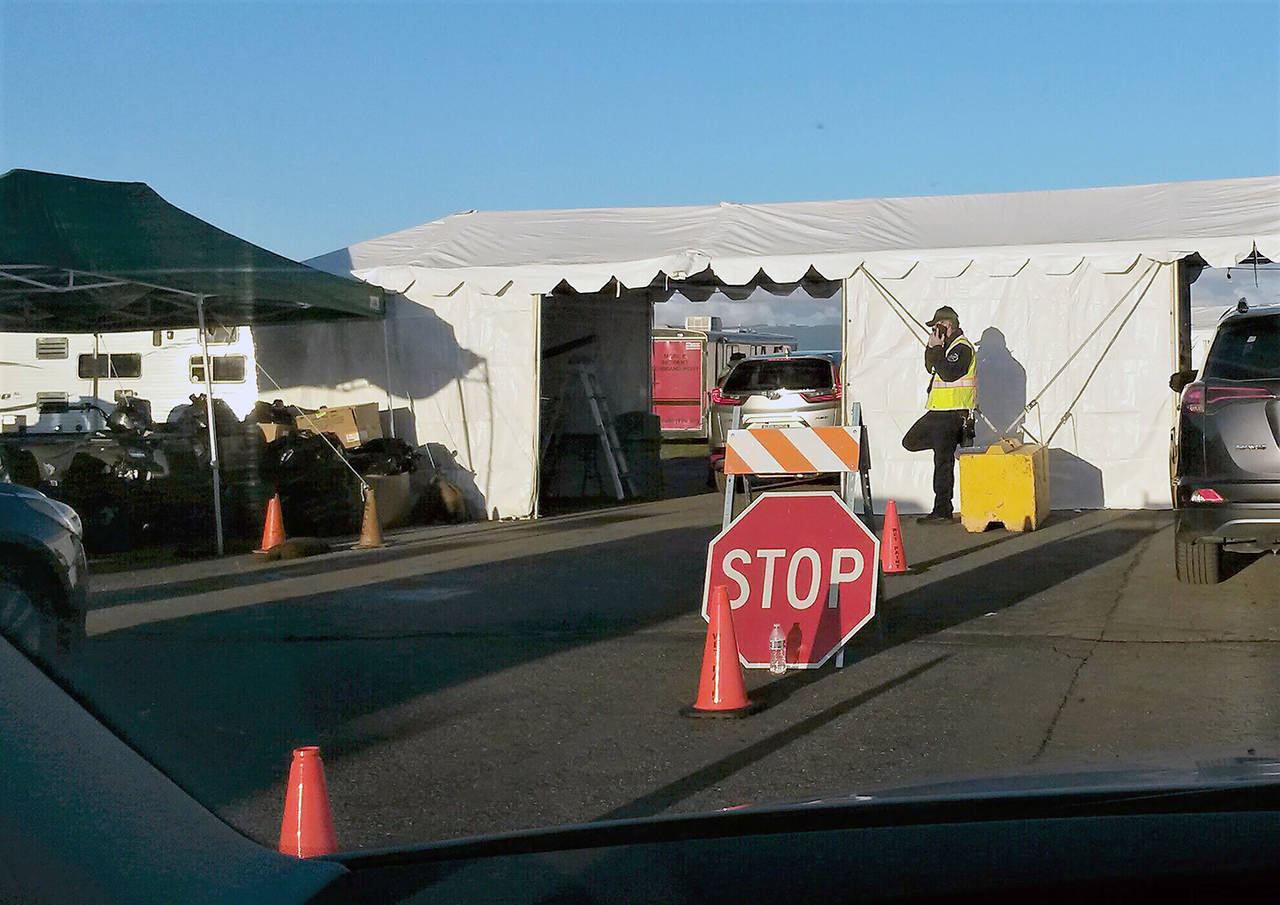 A driver waits at the COVID-19 mass vaccination site Feb. 9 at the Arlington Municipal Airport. (Julie Muhlstein / The Herald)