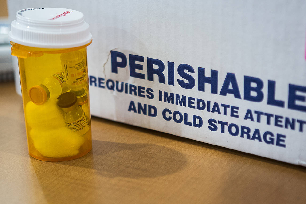 Pfizer COVID-19 vials are taken out of cold storage before use on Friday, Feb. 12, 2021 in Everett, Wa. (Olivia Vanni / The Herald)