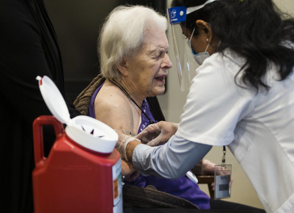 Olivia Vanni / The Herald
Jackie Hoernor, a resident at South Pointe Assisted Living, winces as she gets her Pfizer COVID-19 vaccination during a Walgreen’s Vaccine Clinic at South Pointe on Feb. 12 in Everett.
