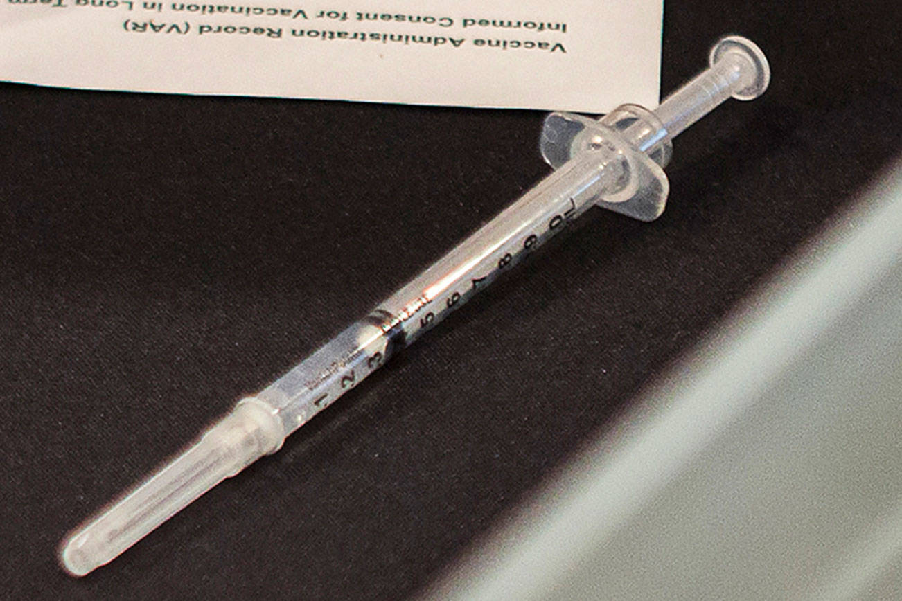 A pre-loaded syringe with the Pfizer COVID-19 vaccine sits on the table for the next person in line during a vaccine clinic as South Pointe Assisted Living on Friday, Feb. 12, 2021 in Everett, Wa. (Olivia Vanni / The Herald)