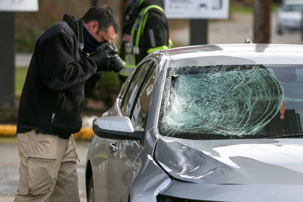 A Washington State Patrol detective photographs the vehicle involved in hit and run double fatality in Bothell Friday on February 19, 2021. (Kevin Clark / The Herald)
