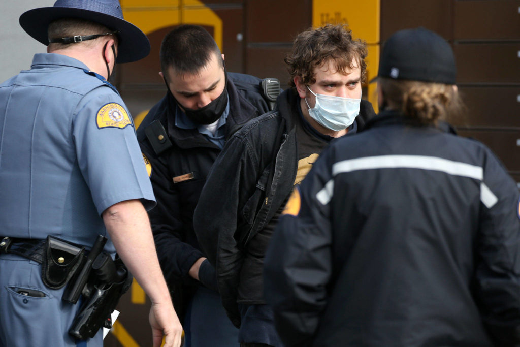 Washington State Patrol officers detain the suspected driver of a hit and run double fatality in Bothell Friday on February 19, 2021. (Kevin Clark / The Herald)
