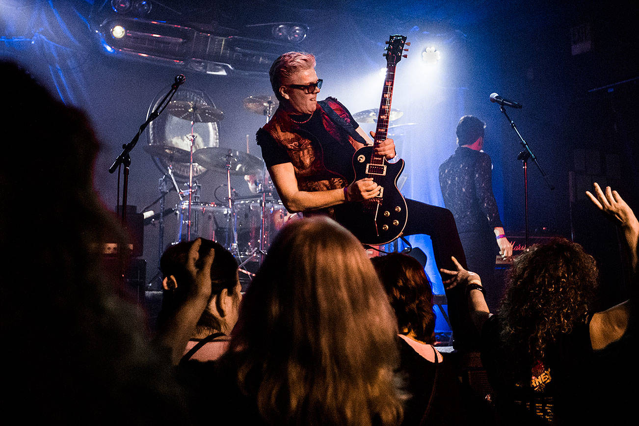 Dave Dodge stands on a speaker while playing his guitar during Nite Wave's show at Tony V's Garage on Saturday, June 8, 2019 in Everett, Wash. (Olivia Vanni / The Herald)