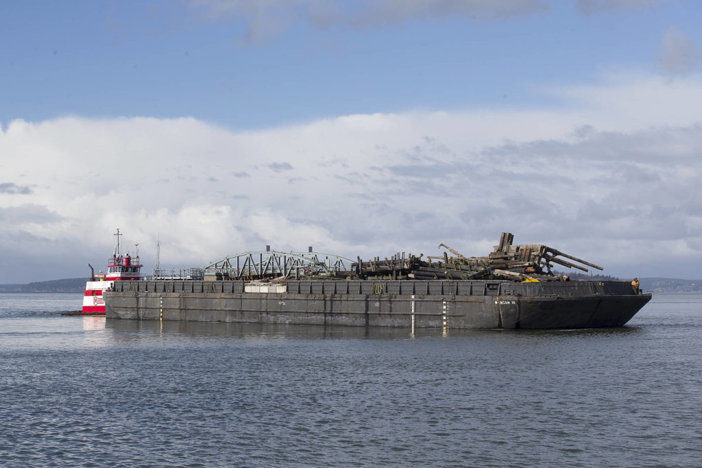 The tug Gladys M carries off the remains of the Mukilteo ferry dock ramp and pier Tuesday. (Andy Bronson / The Herald)
