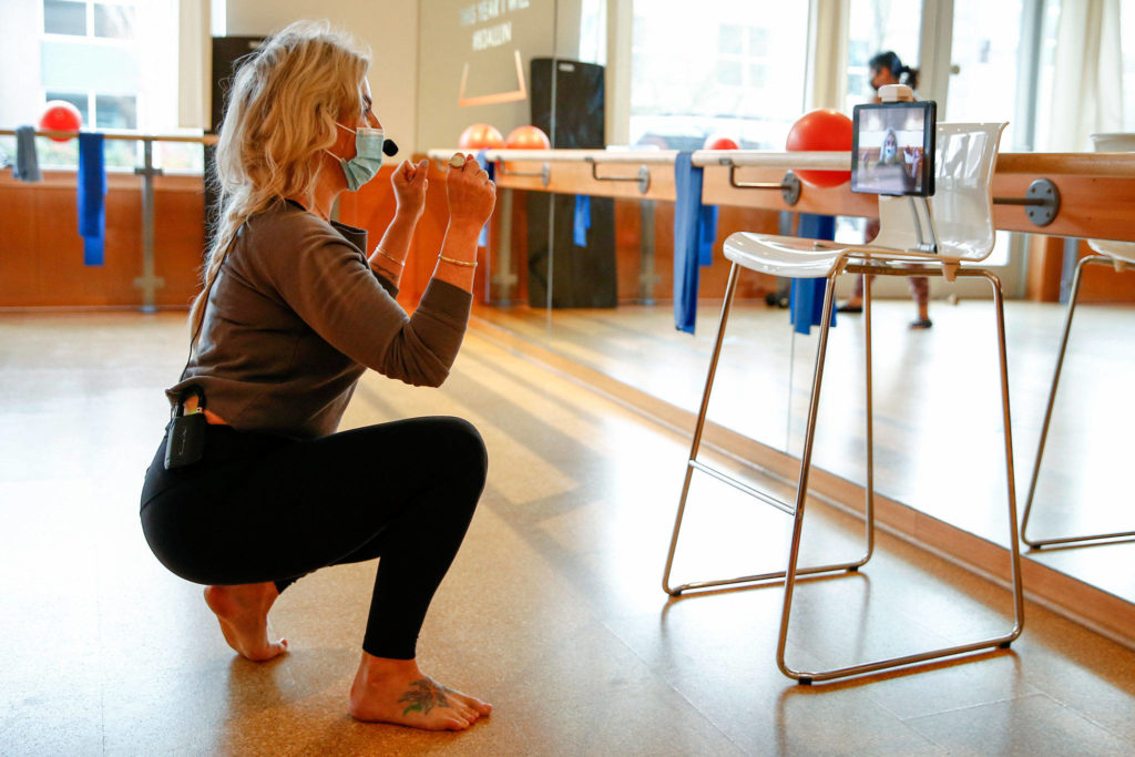 Tawni Dillon welcomes clients for a Saturday morning livestream exercise class in Mill Creek. (Kevin Clark / The Herald)
