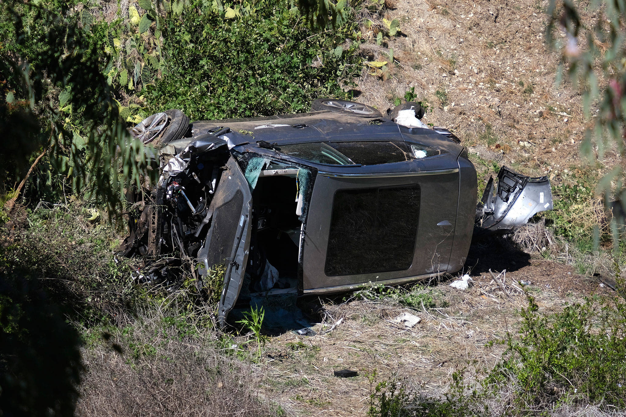 A vehicle rests on its side after a rollover accident involving golfer Tiger Woods along a road in the Rancho Palos Verdes suburb of Los Angeles on Tuesday. (AP Photo/Ringo H.W. Chiu)