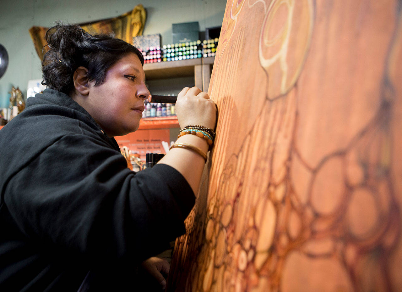 Lu Hernandez paints in her studio Dec. 11, 2020, in Everett. (Olivia Vanni / Herald file)
