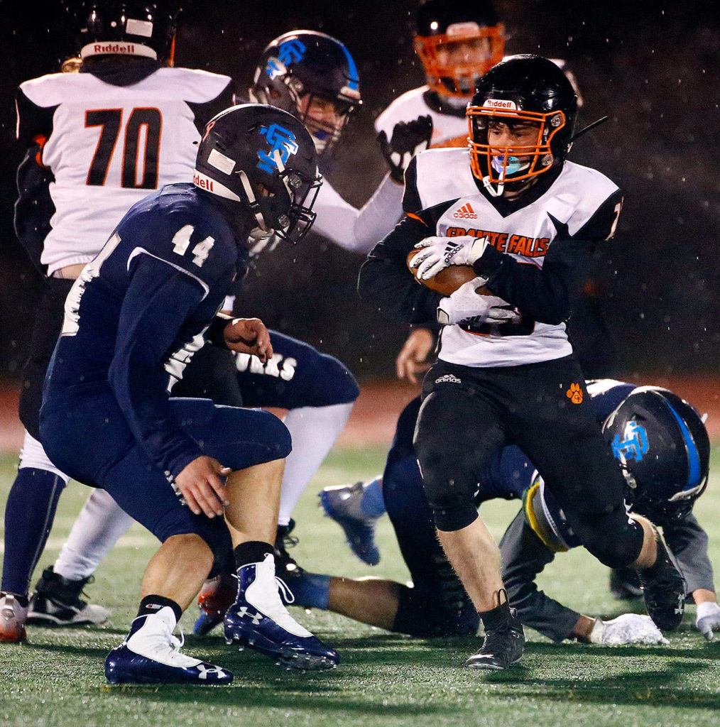 Granite Falls’ Kaleb Roberts carries the ball as Sultan’s Kaden Hardwick closes in. (Kevin Clark / The Herald)
