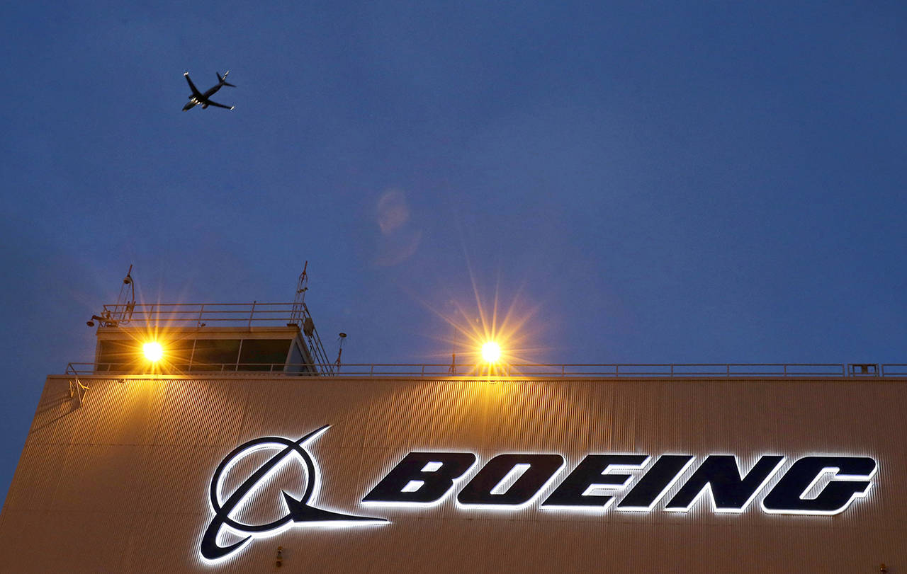 In this 2015 photo, an airplane flies over a sign at Boeing’s newly expanded 737 delivery center at Boeing Field in Seattle. (AP Photo/Ted S. Warren, File)